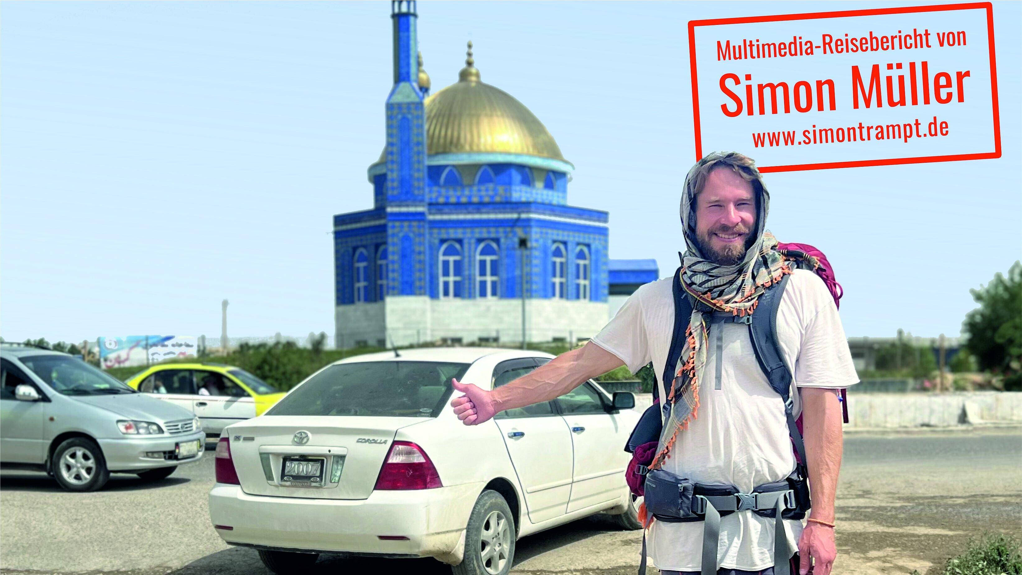 Simon Müller steht mit Daumen nach oben vor einem Auto und einer Moschee. © Simon Müller