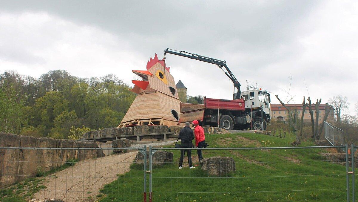 Der Kopf des neuen Huhns wird mit einem Kran auf den Korpus gesetzt