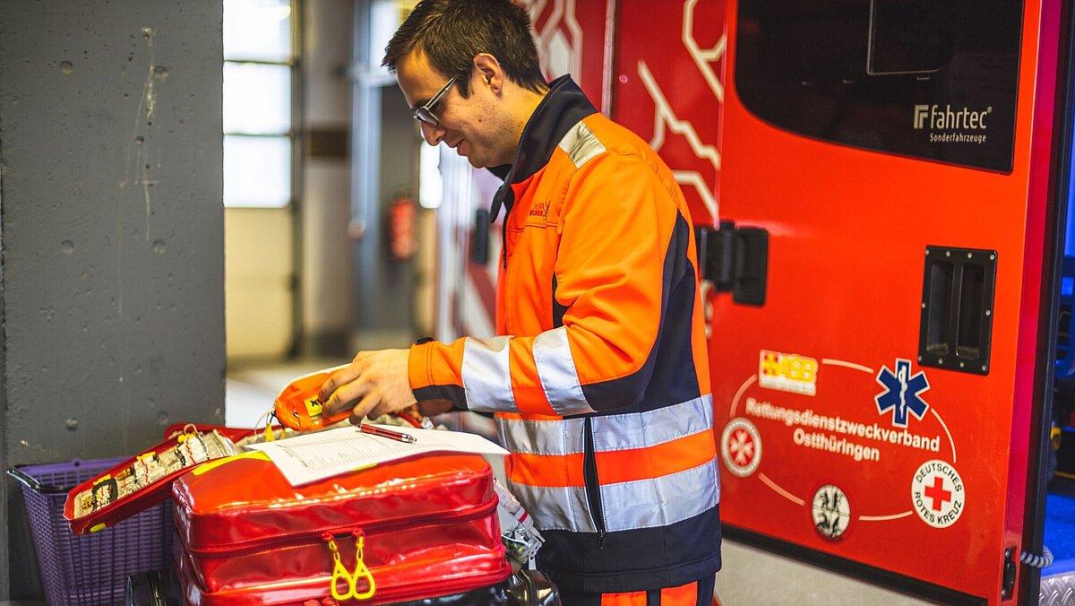 Notfallsanitäter überprüft seinen Rucksack auf Vollständigkeit.