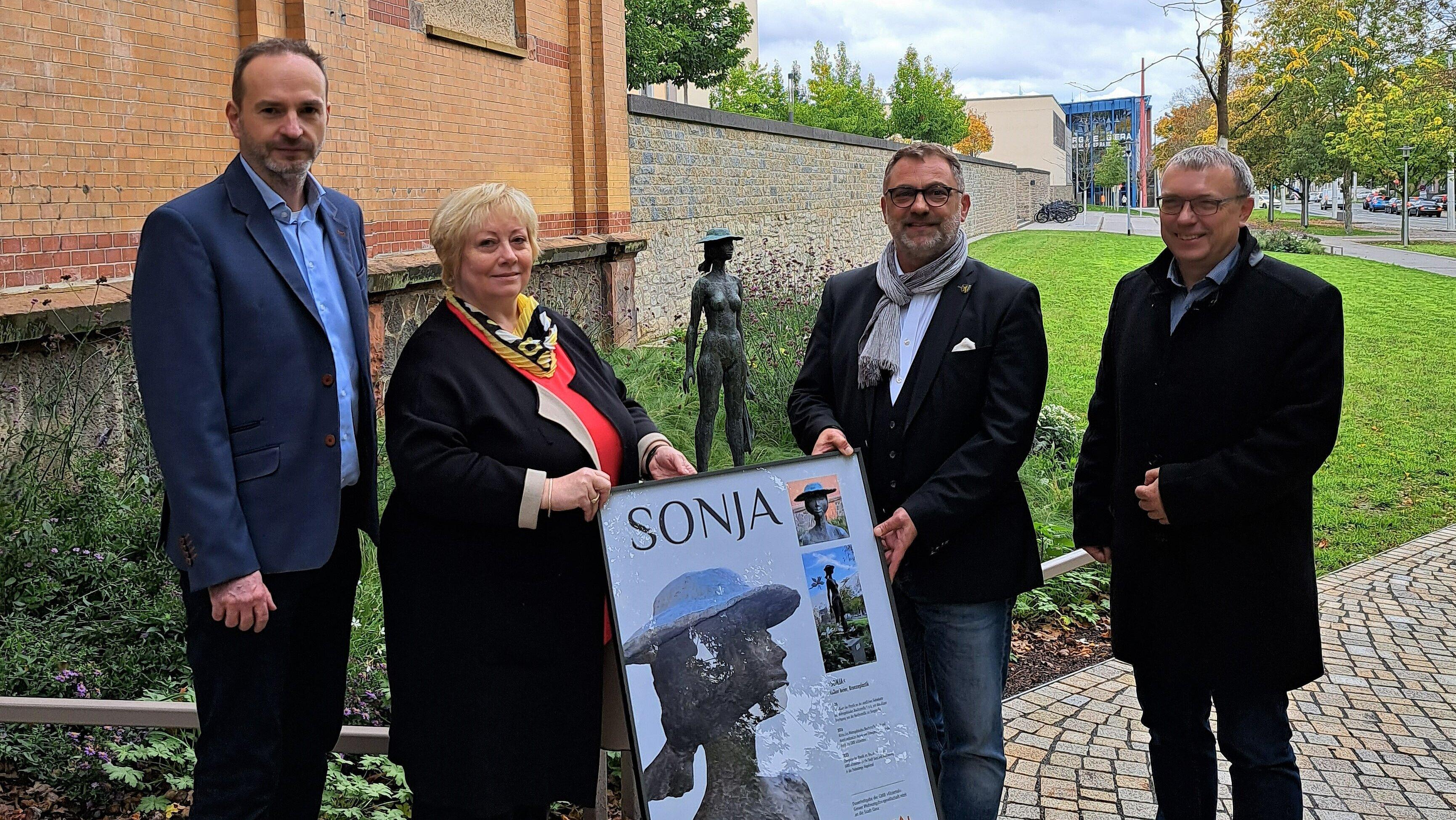 Markus Popp und Martina Schramm von der Geschäftsführung der GWB Elstertal überreichen symbolisch in Form eines Bildes die Plastik "Sonja" an Oberbürgermeister Julian Vonarb und Baudezernent Michael Sonntag (v.l.n.r.)