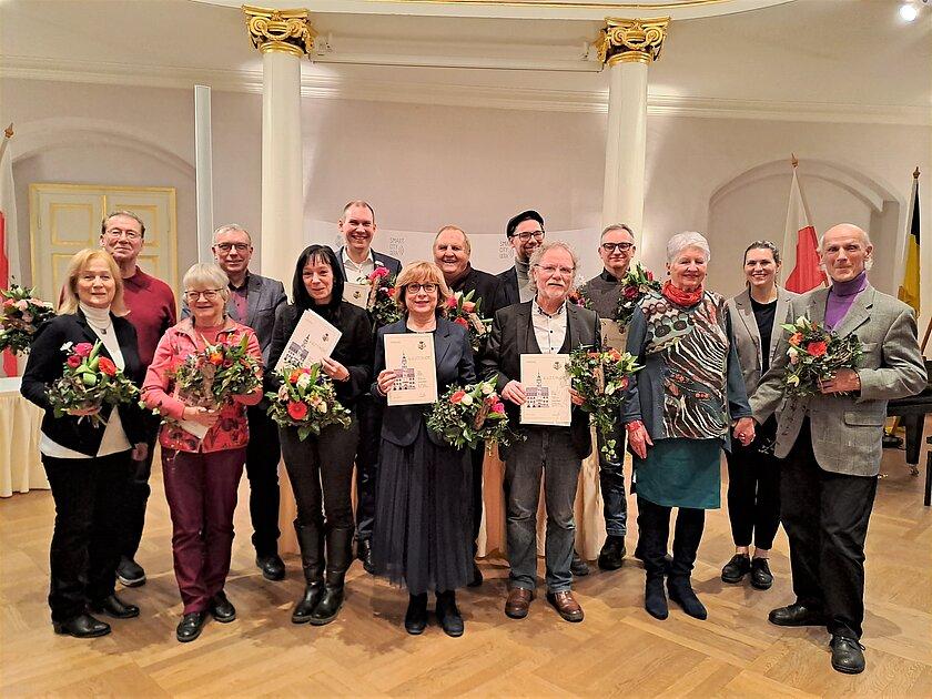 Zwölf Menschen mit Blumen und Urkunden in den Händen. © Stadt Gera