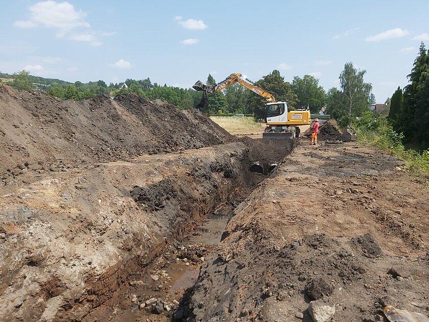 Ein Bagger verfüllt den Rohrgraben. © Stadt Gera