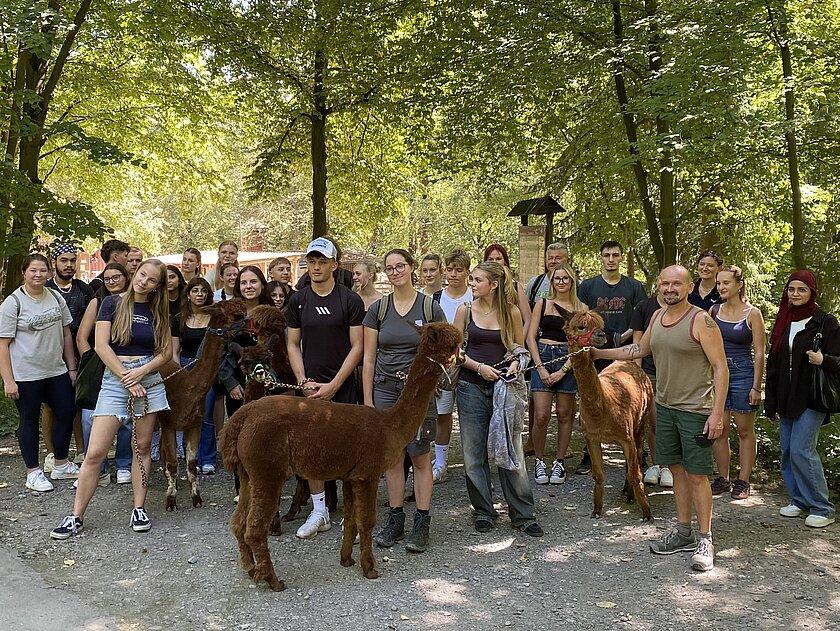 eine große Gruppe von Schülerinnen und Schülern stehen zum Gruppenfoto mit Alpakas im Tierpark. © Stadtverwaltung Gera
