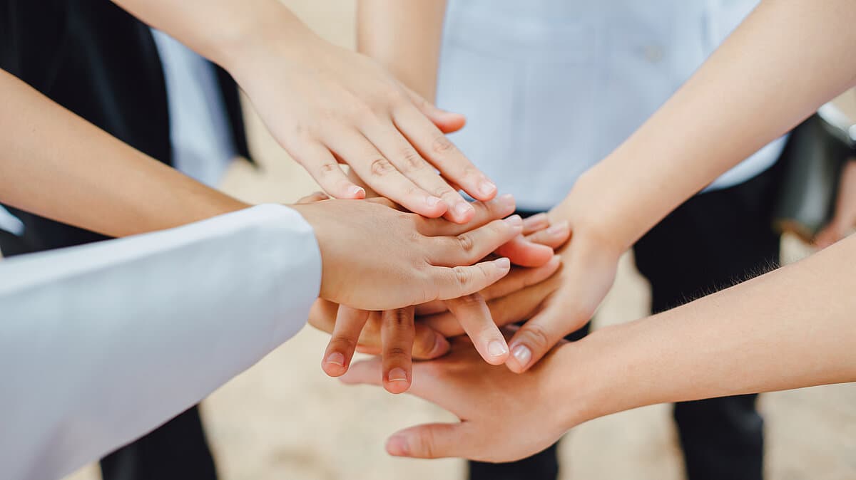 mehrere Hände liegen übereinander. © Adobestock