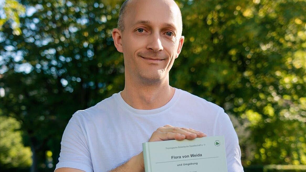 Autor Rico Kaufmann mit seinem Buch "Flora von Weida und Umgebung". © Man Yi