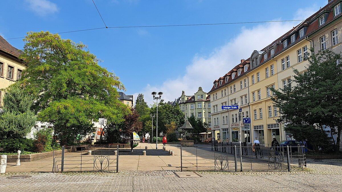 Blick auf einen Platz mit Bänken, einem Spielelement und Grün. © Stadt Gera