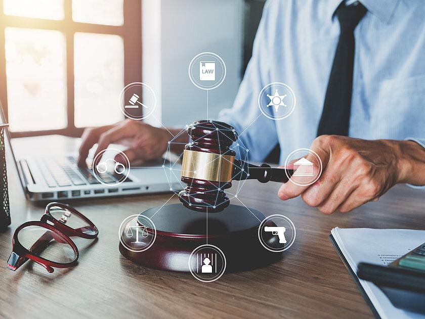 Ein Richterhammer mit mehreren Symbolen um ihn herum. © Mongta Studio - stock.adobe.com
