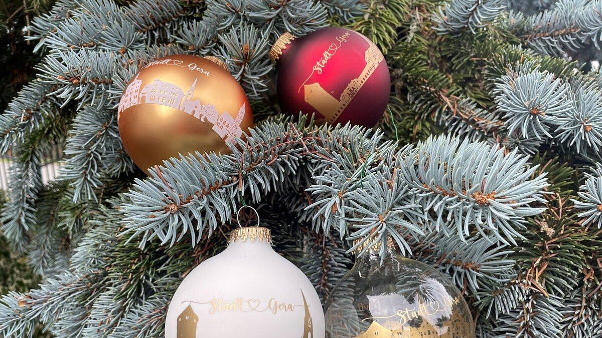 Eine Christbaumkugel mit einer Skyline von Geraer Sehenswürdigkeiten in vier Farben