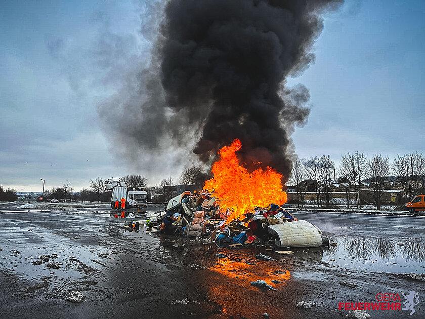 Angezündeter Schrotthaufen wird gelöscht. © Amt für Brand- und Katastrophenschutz