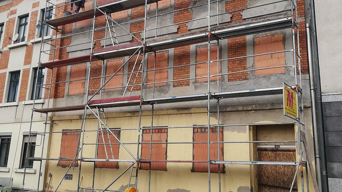 ein baubedürftiges Haus mit Gerüst.