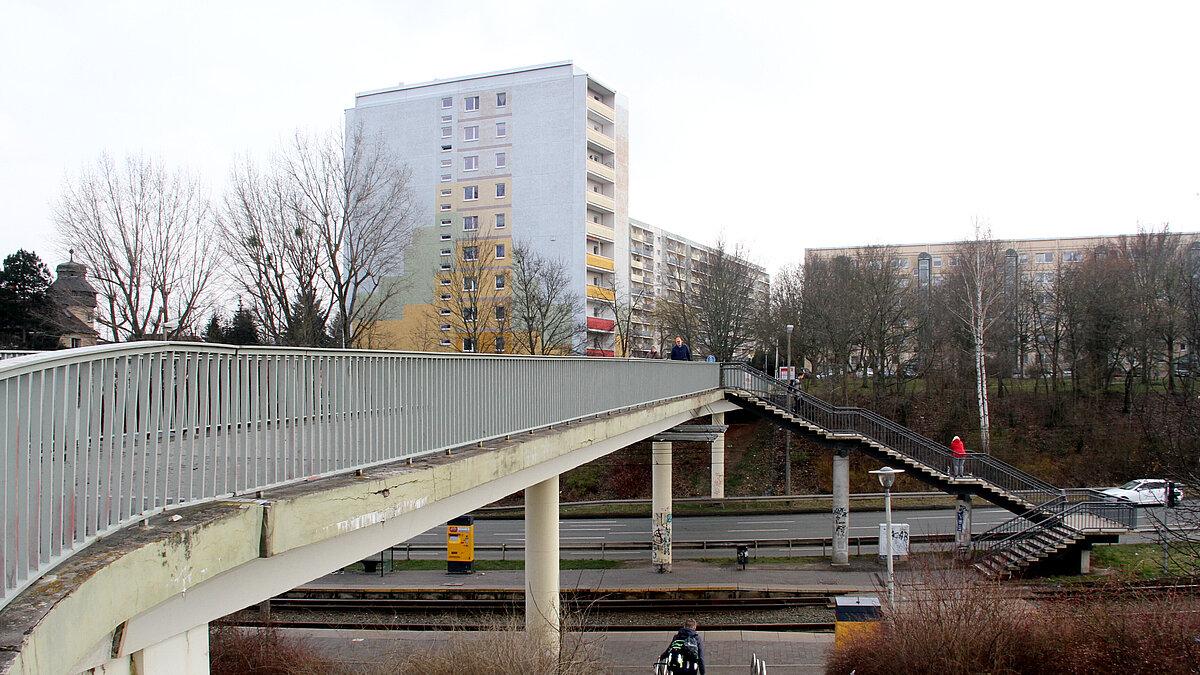 Eine Brücke, über die Fußgänger die Straßenbahnschienen und zwei Straßen queren können
