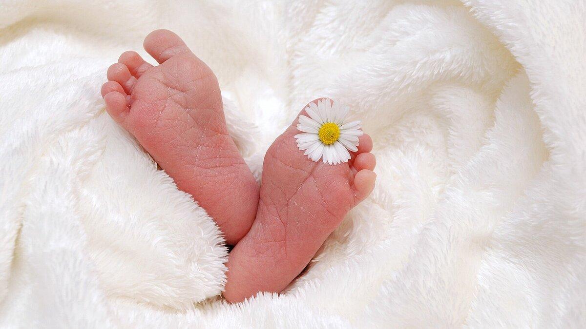 Babyfüße eingeweickelt in einer Decke.