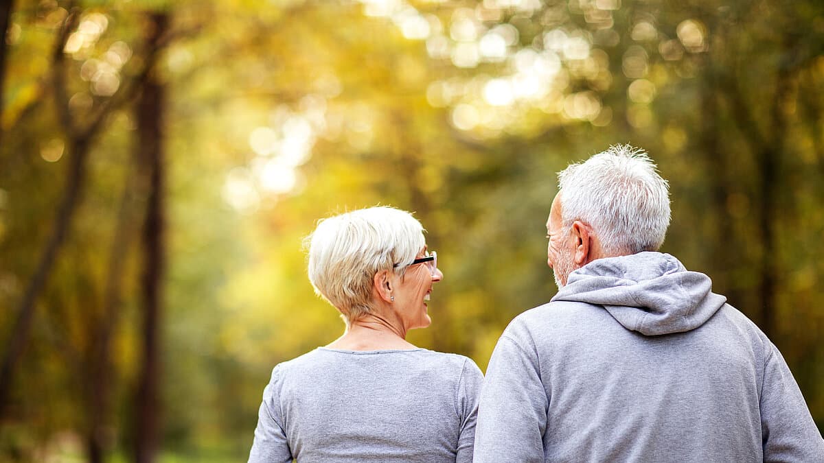 grauhaariges Frau und grauhaariger Mann in Jogging-Kleidung von hinten. © Adobe Stock