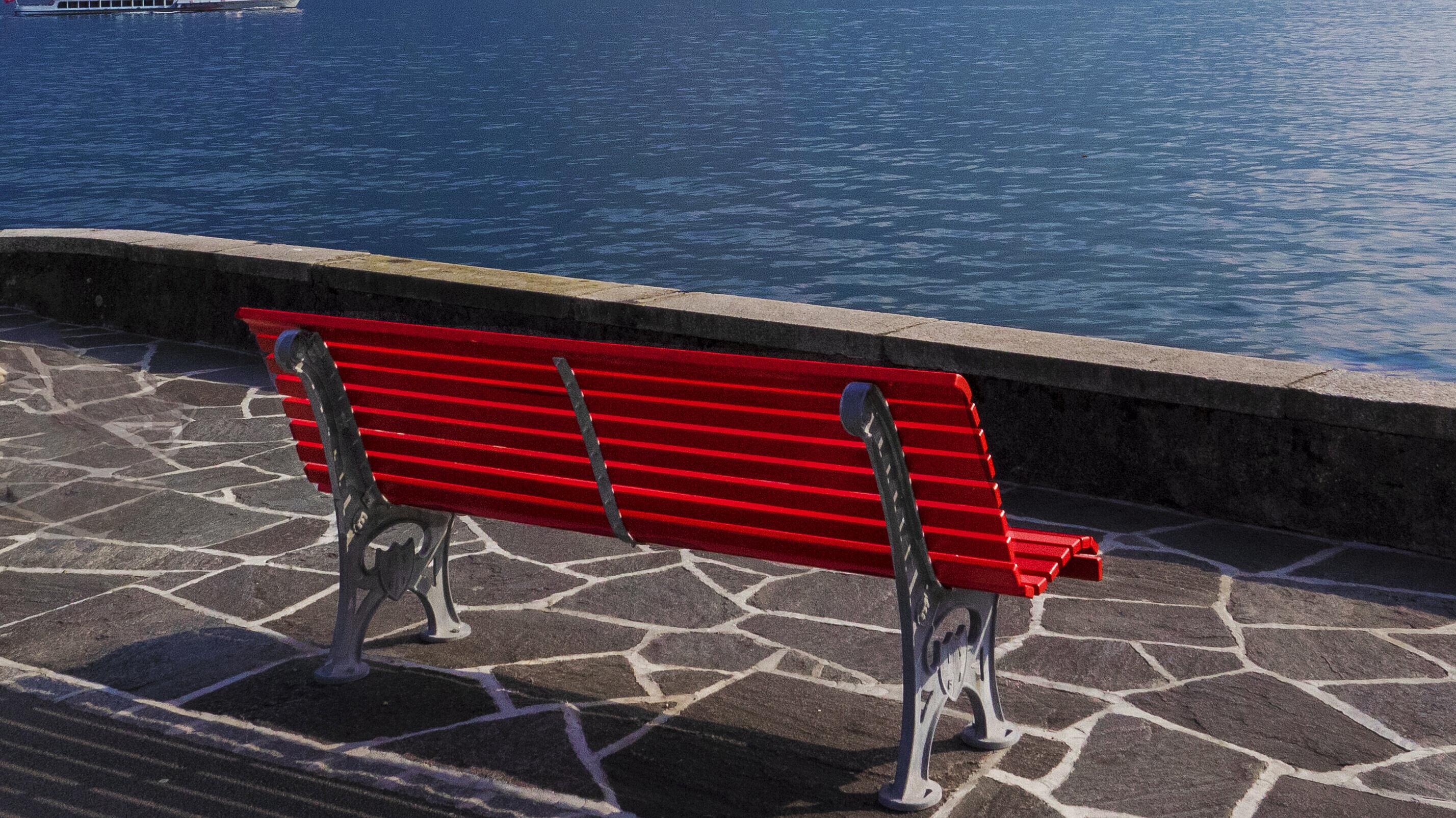 Eine rote Bank an seinem großen See. © AdobeStock