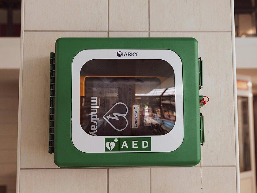 Ein Defibrillator hängt an der Wand. © pexels