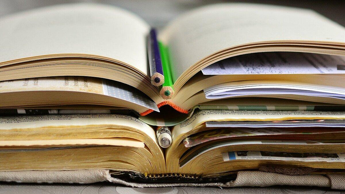 Mehrere Bücher liegen aufgeschlagen übereinander