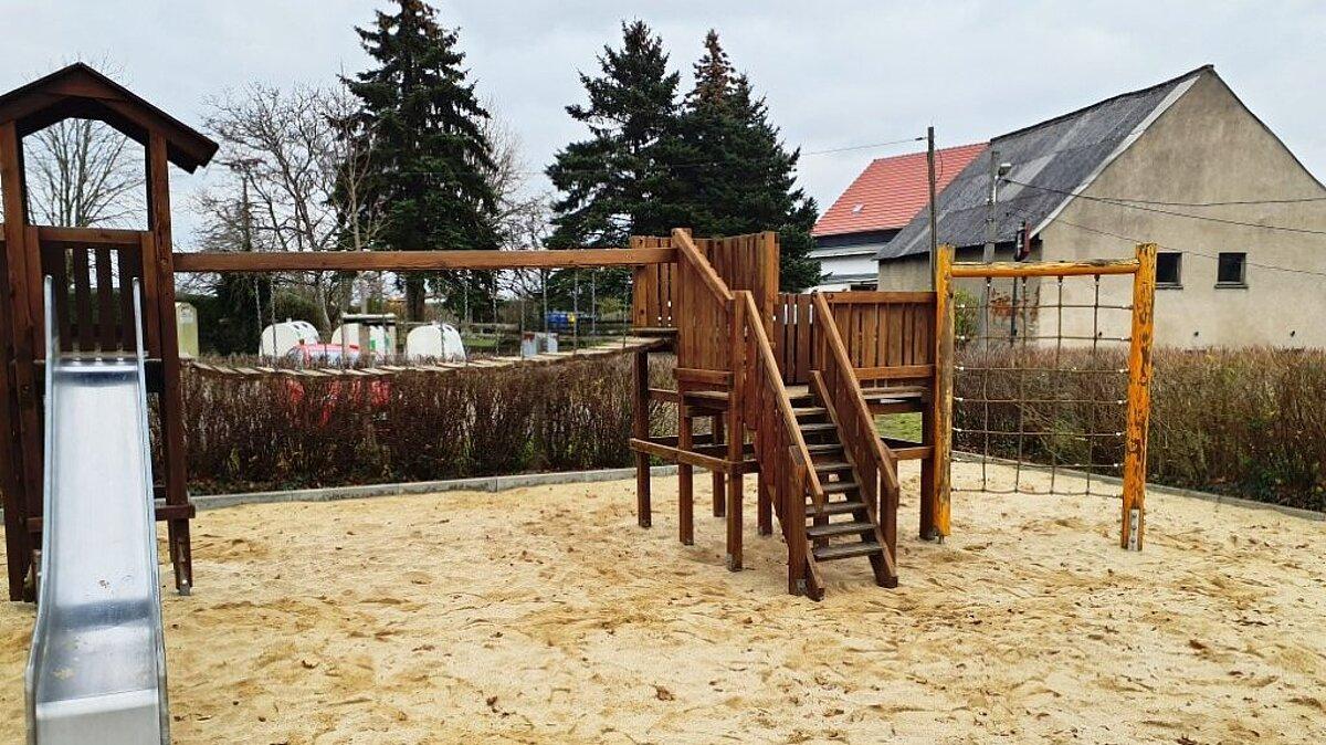 Eine Spielgerätekombination aus Holz auf einem Sandplatz. © Stadt Gera
