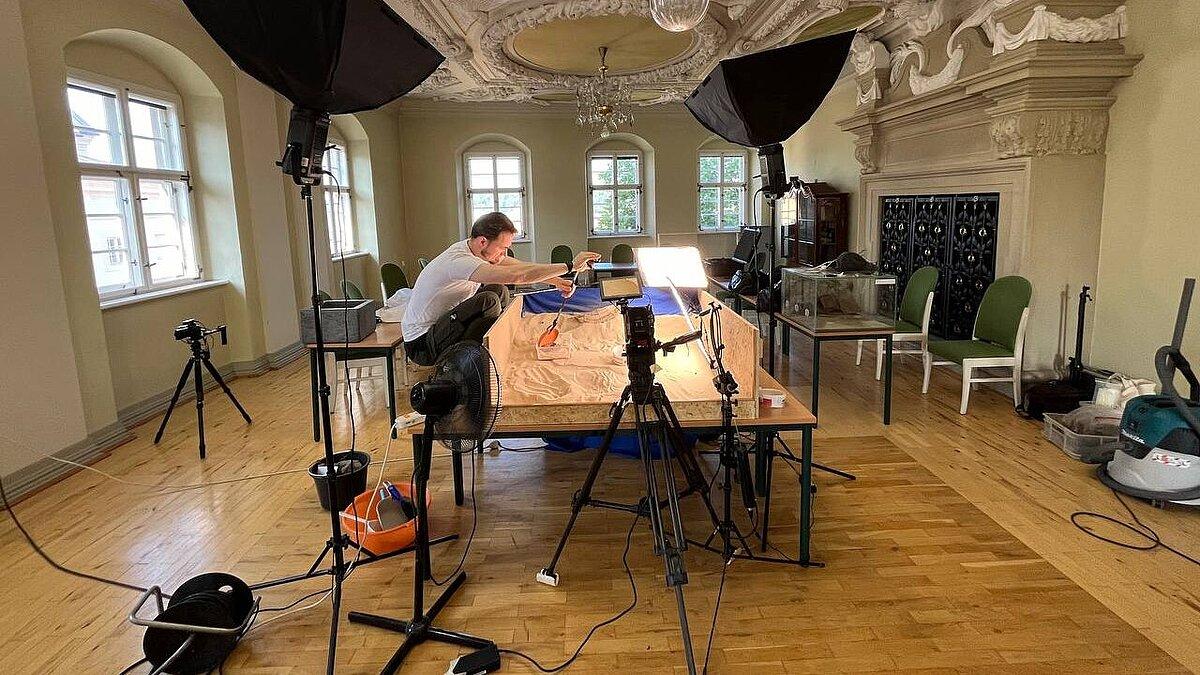 ein Mann der während eines Fotoshootings mit Sand hantiert .