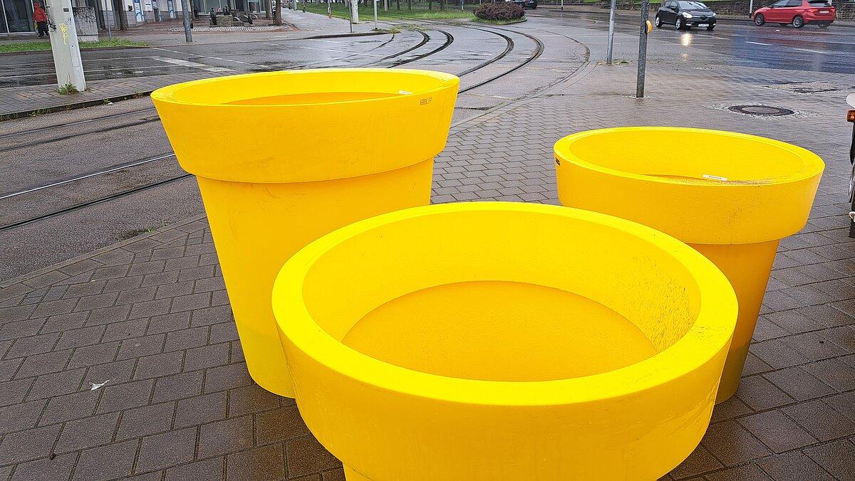 Drei unterschiedlich große, gelbe Pflanzkübel, die an einer Straßenecke stehen. © Stadt Gera