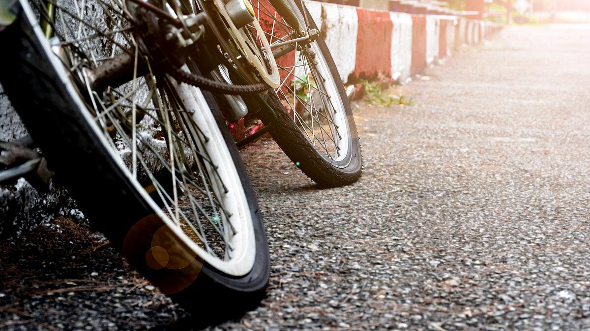 Ein Fahrrad angelehnt an einen Bordstein. © Sophon_Nawit - stock.adobe.com