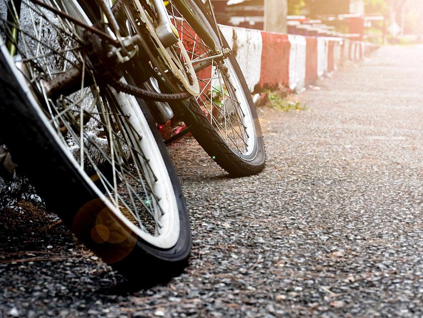 Ein Fahrrad angelehnt an einen Bordstein. © Sophon_Nawit - stock.adobe.com
