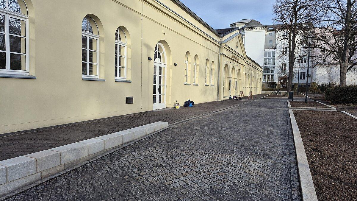 Puppentheater, gepflasterte Fläche davor, rechts: eingefasste Beete. © Stadt Gera