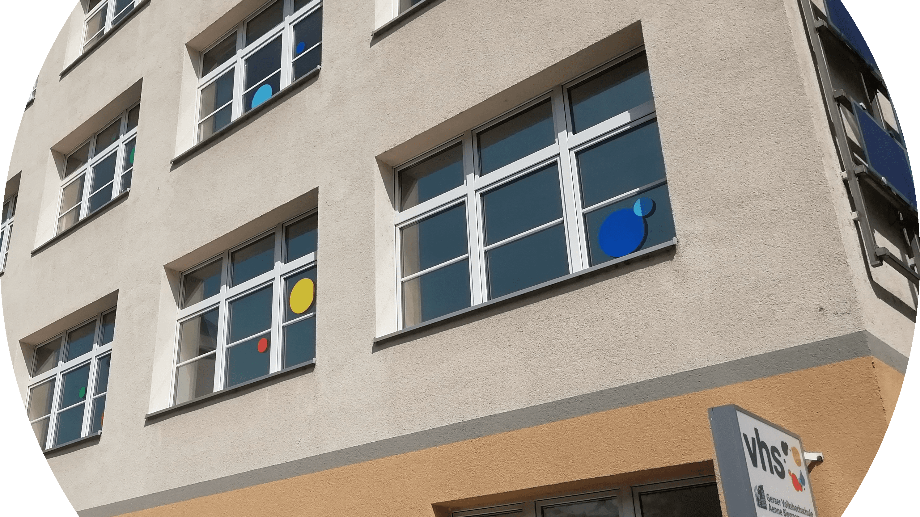 Bunte Fensterbeklebungen an einem Gebäude in Form von Kreisen.. © Geraer VHS

