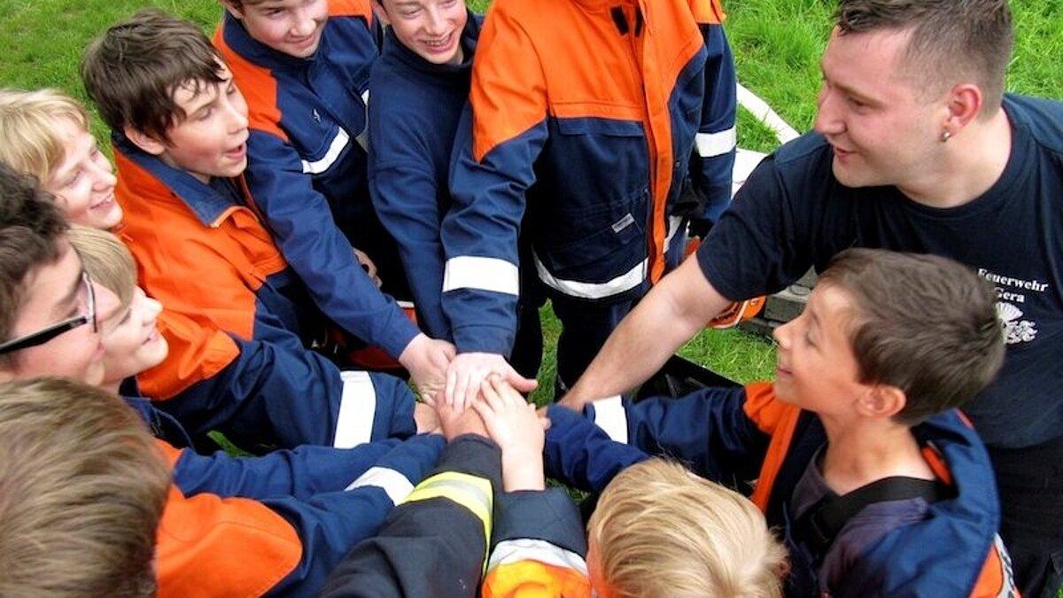 Die Jugendfeuerwehr hat sich in einem Kreis versammelt um einzuklatschen