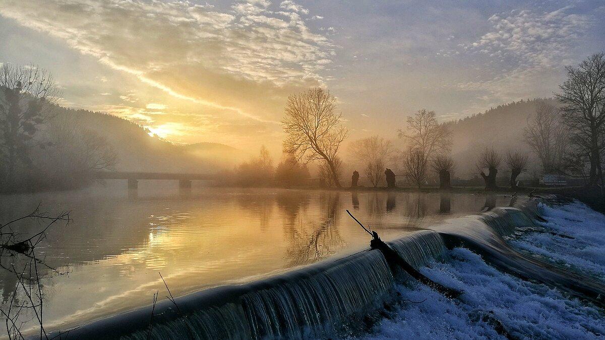 Blick auf die aufgestaute Weiße Elster in Wünschendorf bei Sonnenaufgang in leichtem Nebel. © Sven Landmann