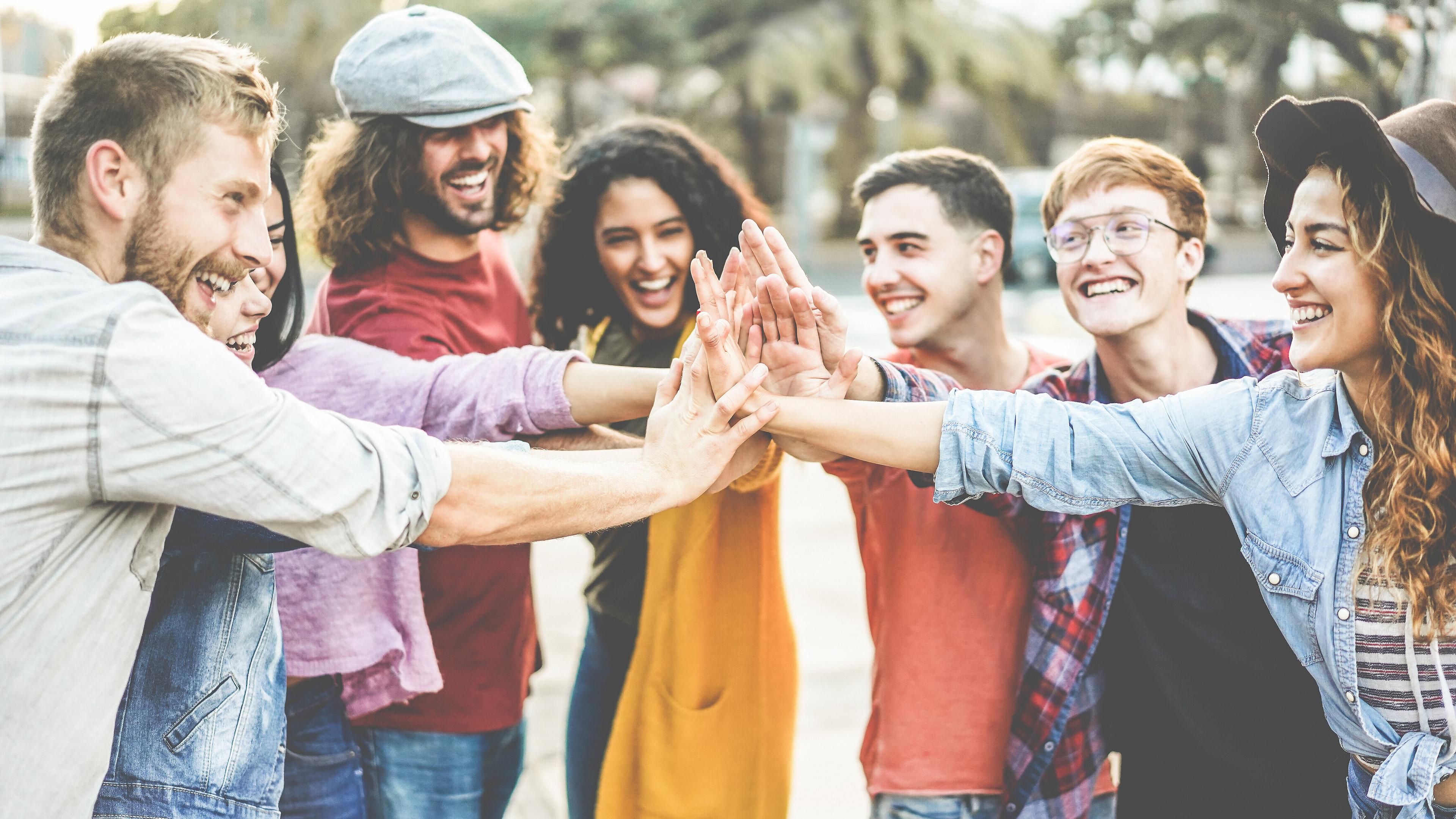 Gruppe Menschen geben sich ein High Five. © stock.adobe.com