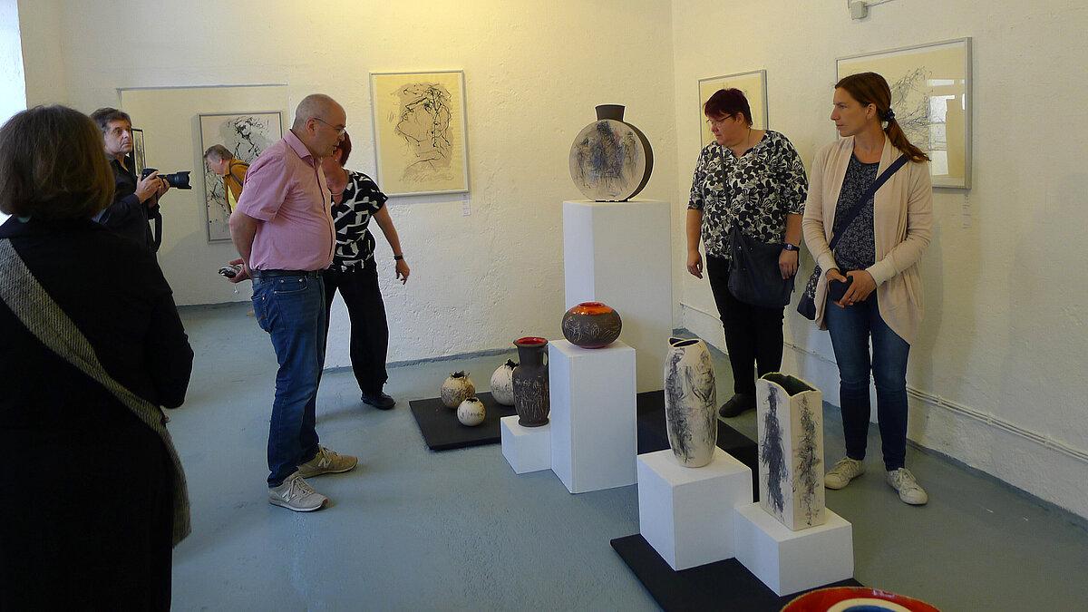 6 Menschen betrachten Keramikvasen in unterschiedlichen Größen. © Sven Schmidt