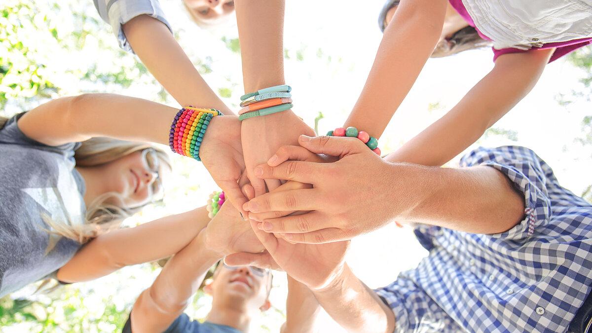 Jugendliche halten Hände zusammen