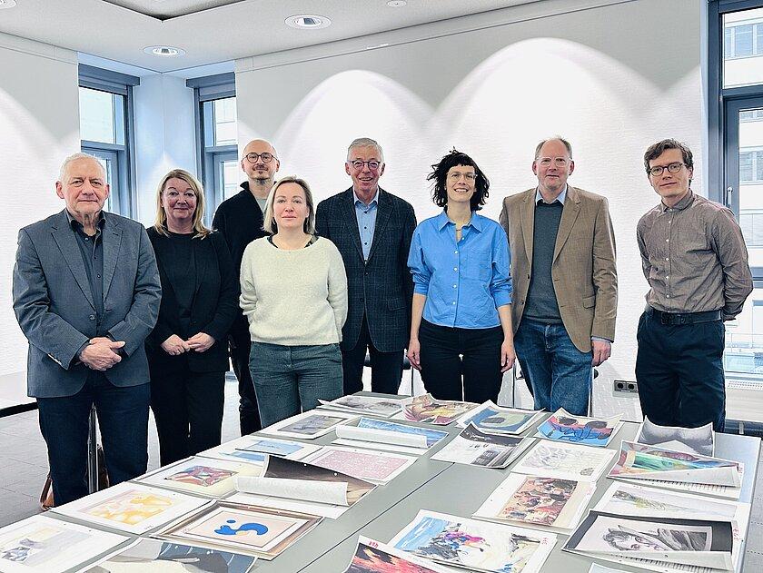 3 Frauen und 5 Männer stehen hinter den ausgedruckten Malereien. © Stadt Gera