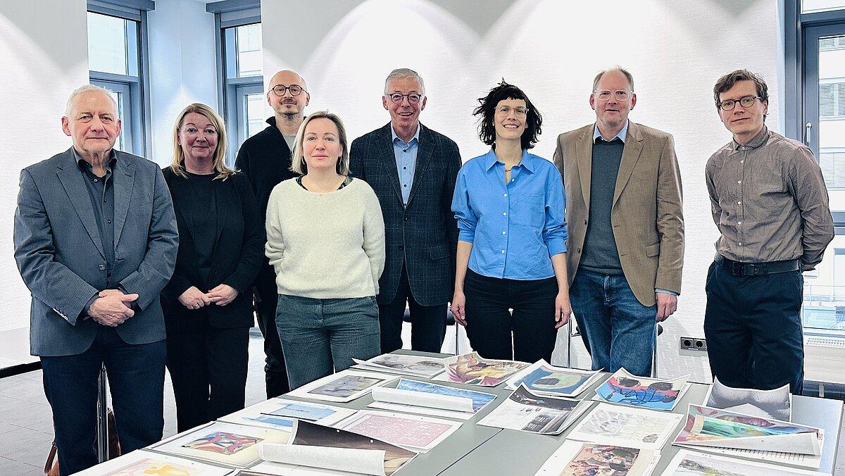 3 Frauen und 5 Männer stehen hinter den ausgedruckten Malereien. © Stadt Gera