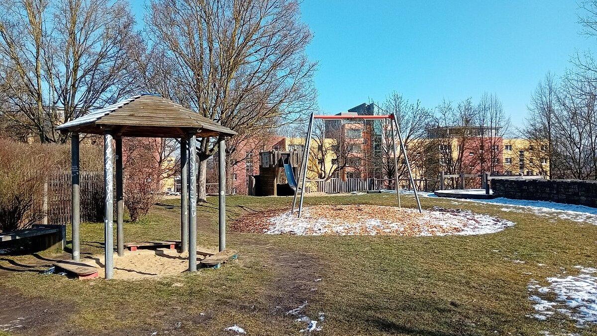Ein Schaukel, ein Unterstand und eine Sandfläche umgeben von Gras. © Stadt Gera