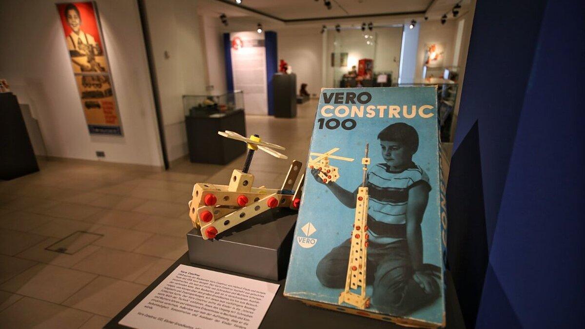 Blick in die Ausstellung - blauer Baukasten Vero Construct mit zusammengebautem Hubschrauber. © Tim Christensen