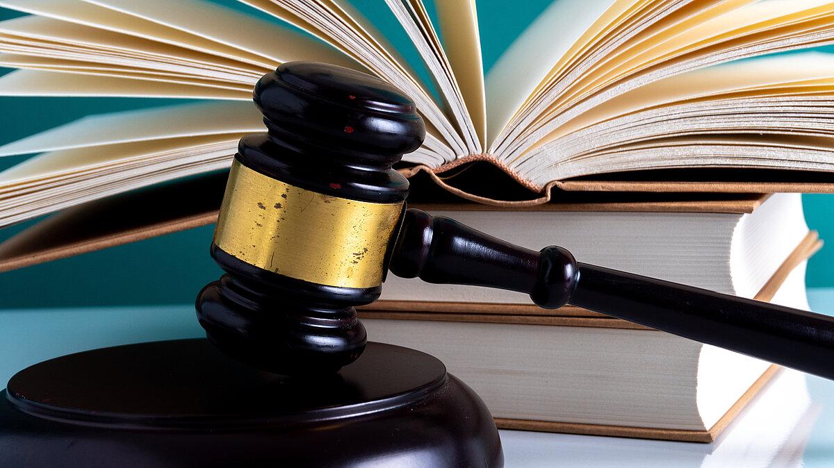 offenes Buch mit einem Richterhammer. © mawardibahar - stock.adobe.com