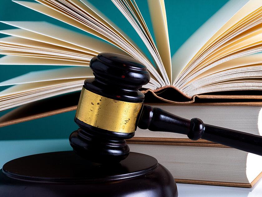 offenes Buch mit einem Richterhammer. © mawardibahar - stock.adobe.com