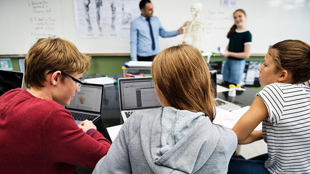 Symbolbild Schule, Schüler sitzen an ihre Tischen
