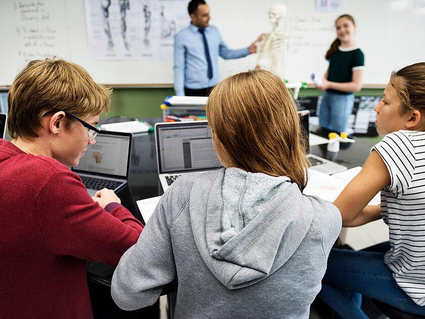 Symbolbild Schule, Schüler sitzen an ihre Tischen