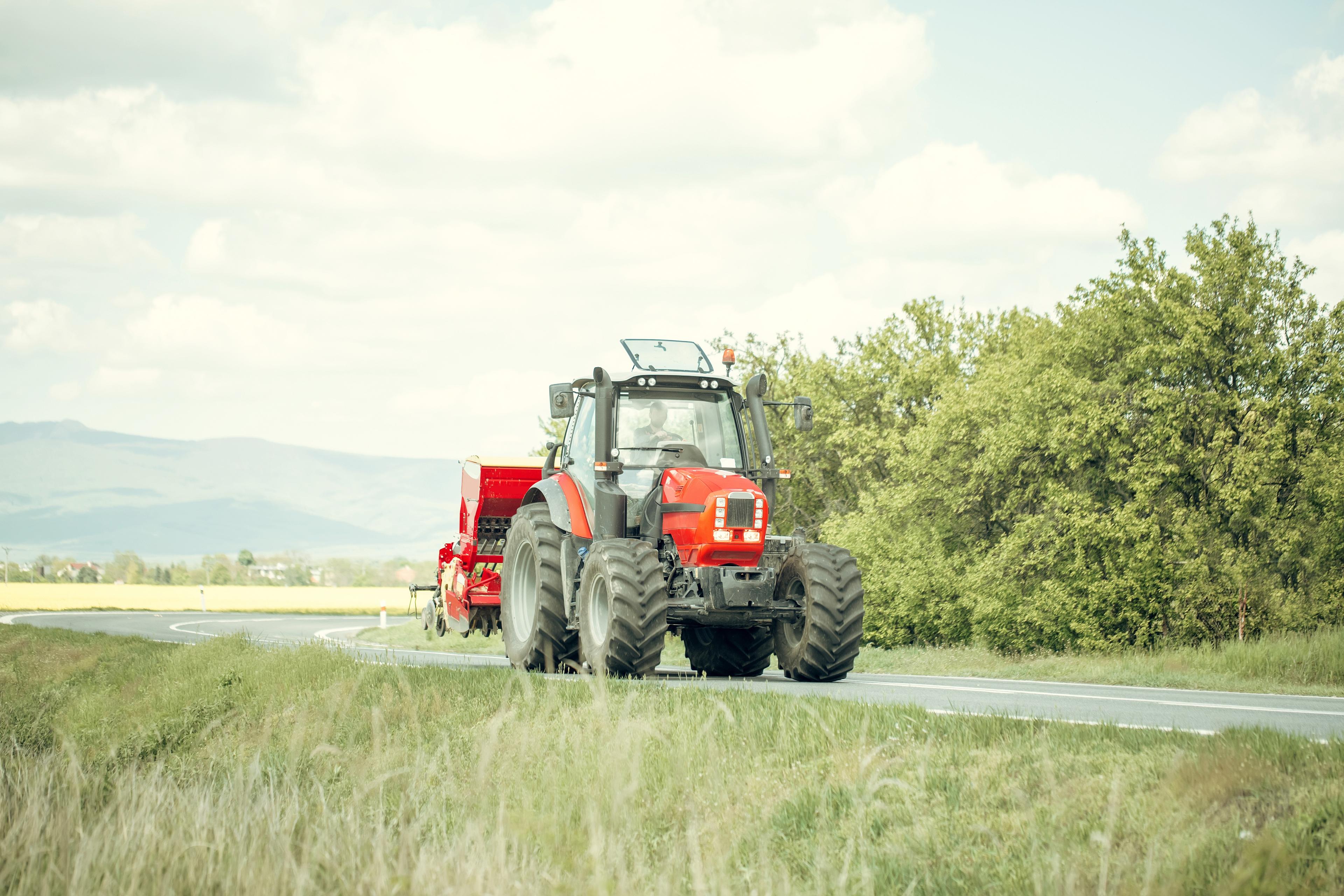 ein roter Traktor fährt auf einer Straße. © Volodymyr - stock.adobe.com