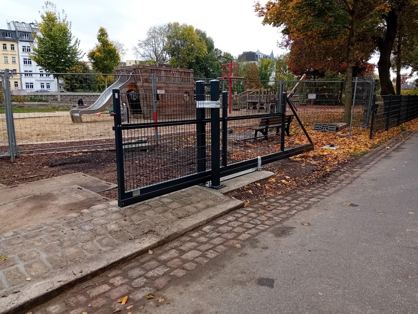Ein neues Rolltor samt Zaun vor einem Spielplatz in Piratenschiff-Form. © Stadt Gera