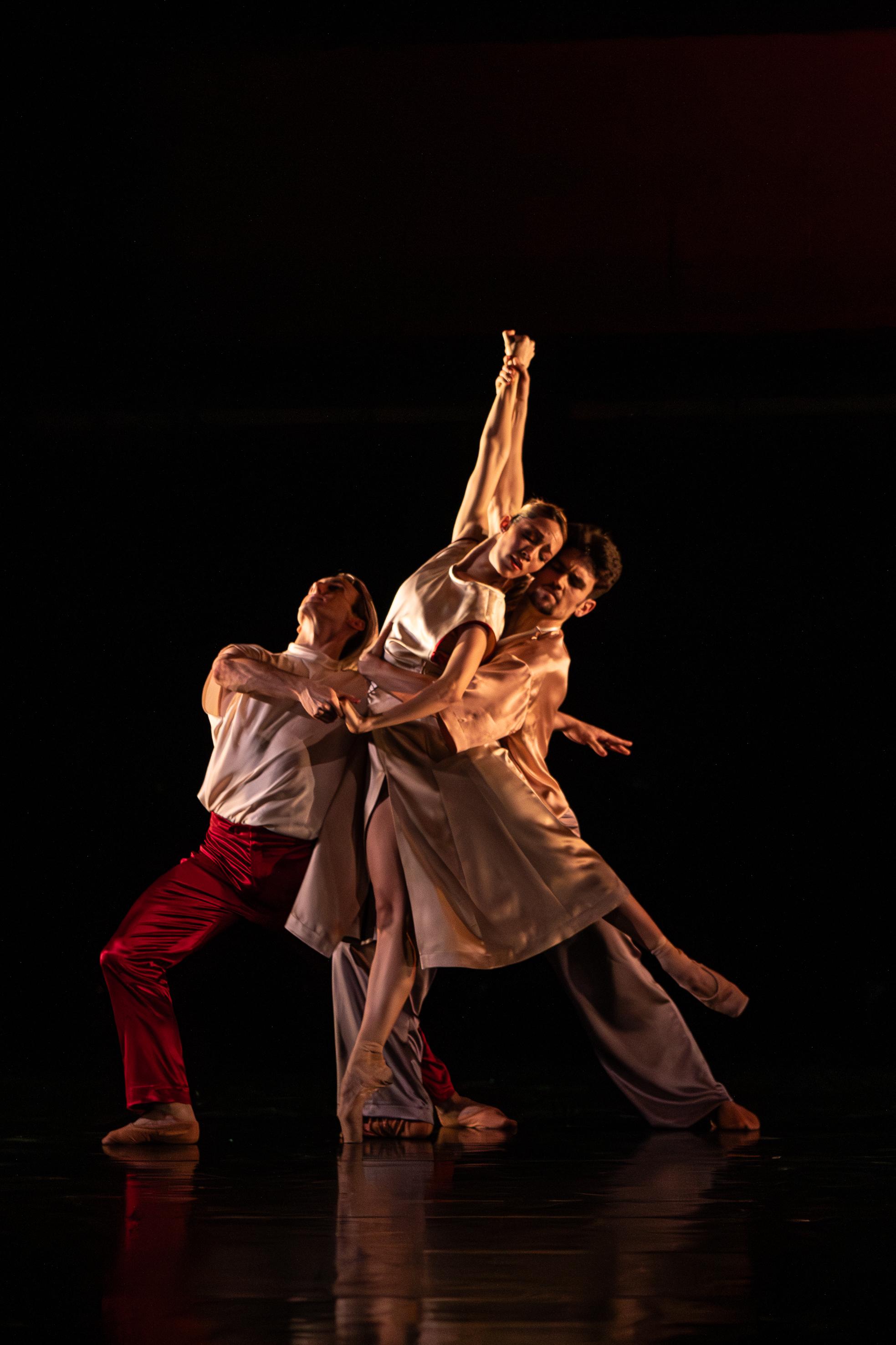 Eine Gruppe tanzender Schauspieler in weißen Gewändern während einer Vorstellung