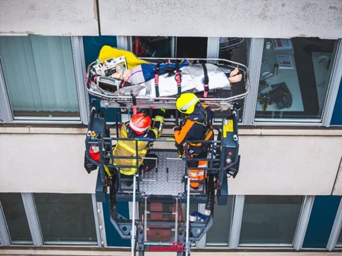 Patient wird in einer Trage über eine Drehleiter aus dem Fenster eines Gebäudes transportiert. © Stadt Gera, Amt für Brand- und Katastrophenschutz