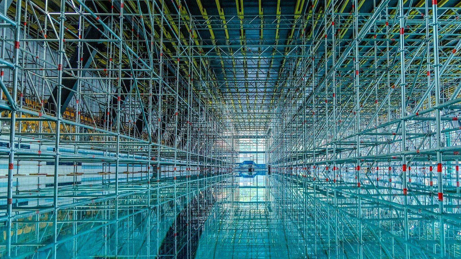 Eine Innenaufnahme des Hofwiesenbads auf der man sieht, wie ein riesiges Gerüst im großen Becken steht. © Stadt Gera