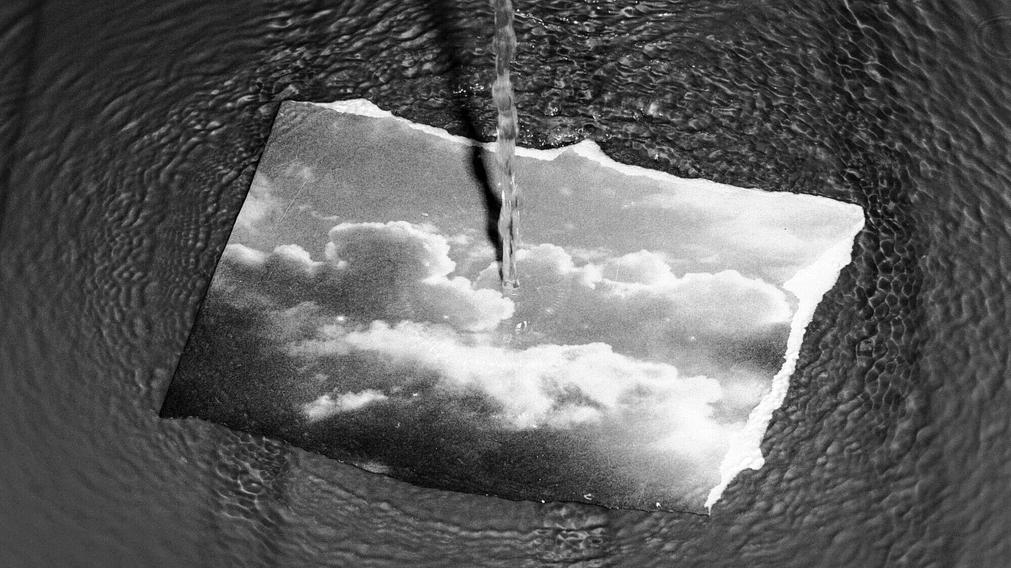 Foto eines Fotos mit Wolken, dass in einer Wasserlache liegt. © Martin Ruckert