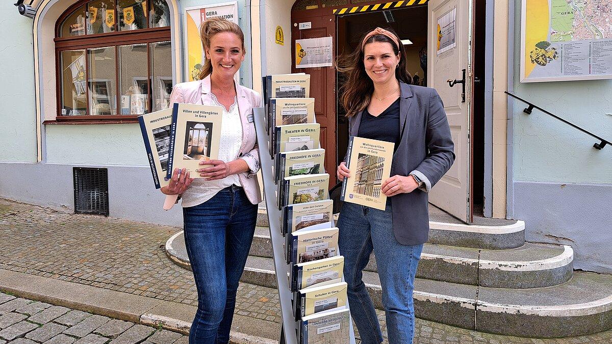 Zwei Frauen, die verschiedene Ausgaben einer Schriftenreihe präsentieren. © Stadt Gera
