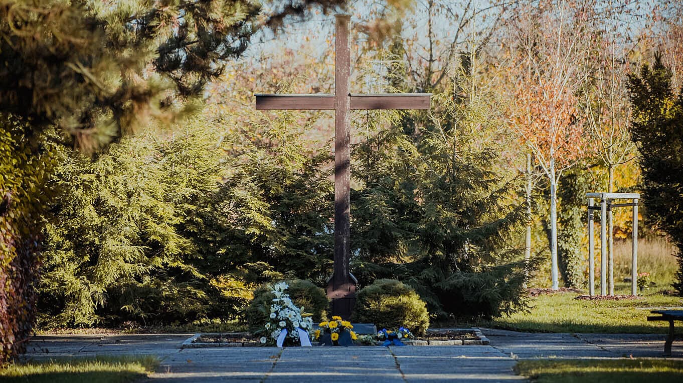 großes Holzkreuz, davor Blumenkränze. © Stadt Gera
