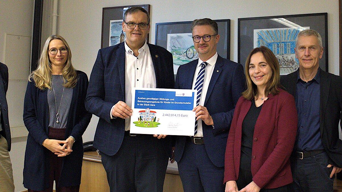 Offizielle Scheckübergabe mit Bertram Koch (Baudezernent), Sandra Wanzar (Dezernentin für Soziales, Jugend und Kultur), Oberbürgermeister Kurt Dannenberg, Christian Tischner (Minister für Bildung, Wissenschaft und Kultur), Cornelia Müller (Schulamt), Dr. Frank Rühling (Leiter Amt für Bildung und Sport) und Birgit Zobel (Leiterin Amt für Hochbau und Liegenschaften), v.l.n.r.. © Stadt Gera