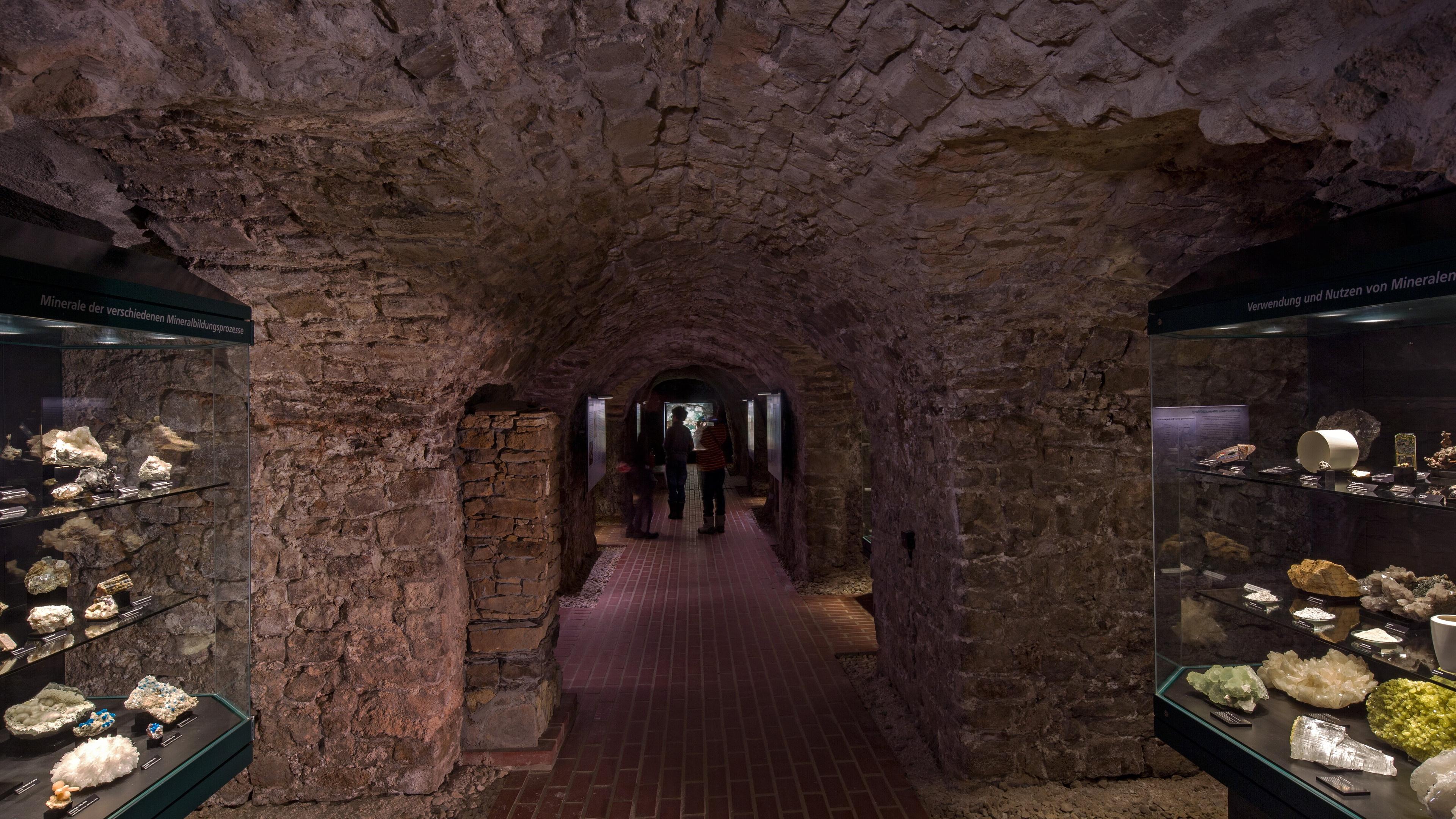 Tiefe Kellergewölbe (Höhler) mit Vitrinen links und rechts, darin Mineralien. © ARTwork-stewe